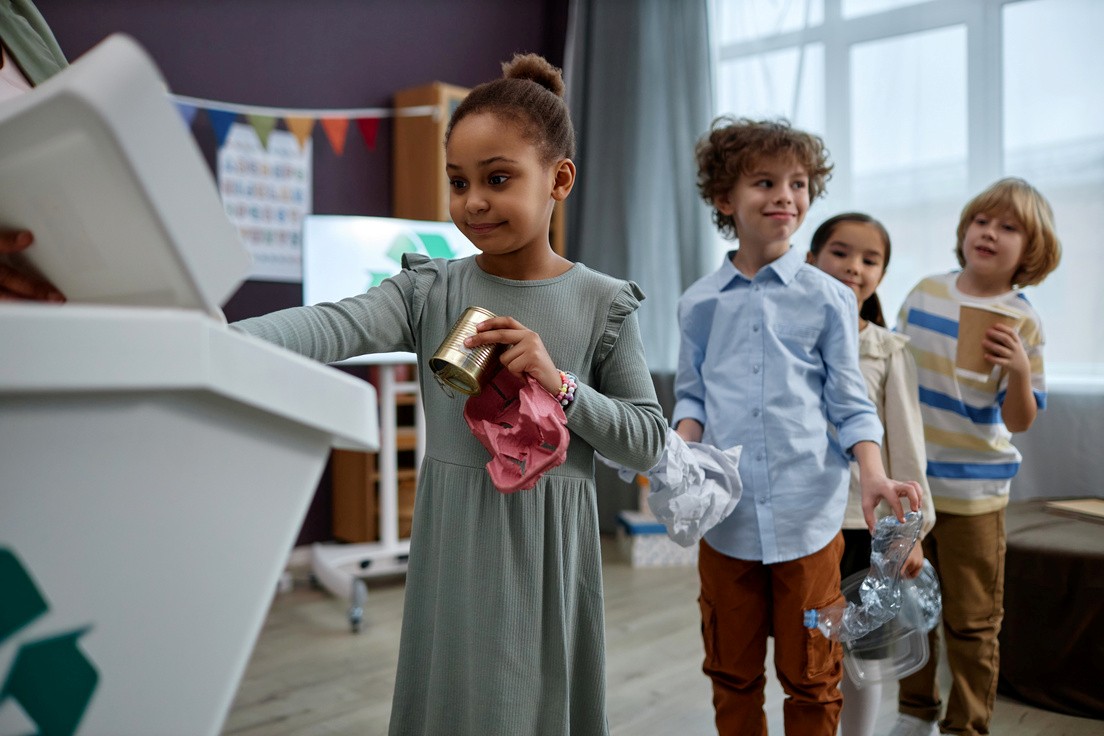 Schulkinder sortieren Müll im Unterricht.